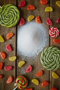 Assortment of colorful candies, lollipops and pile of sugar