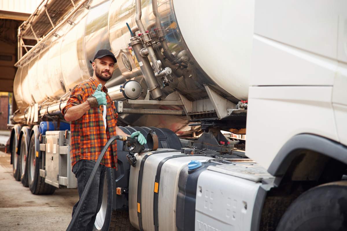 Holding refueling petrol and adblue/diesel exshaust fluid (def). Young truck driver in casual clothes.