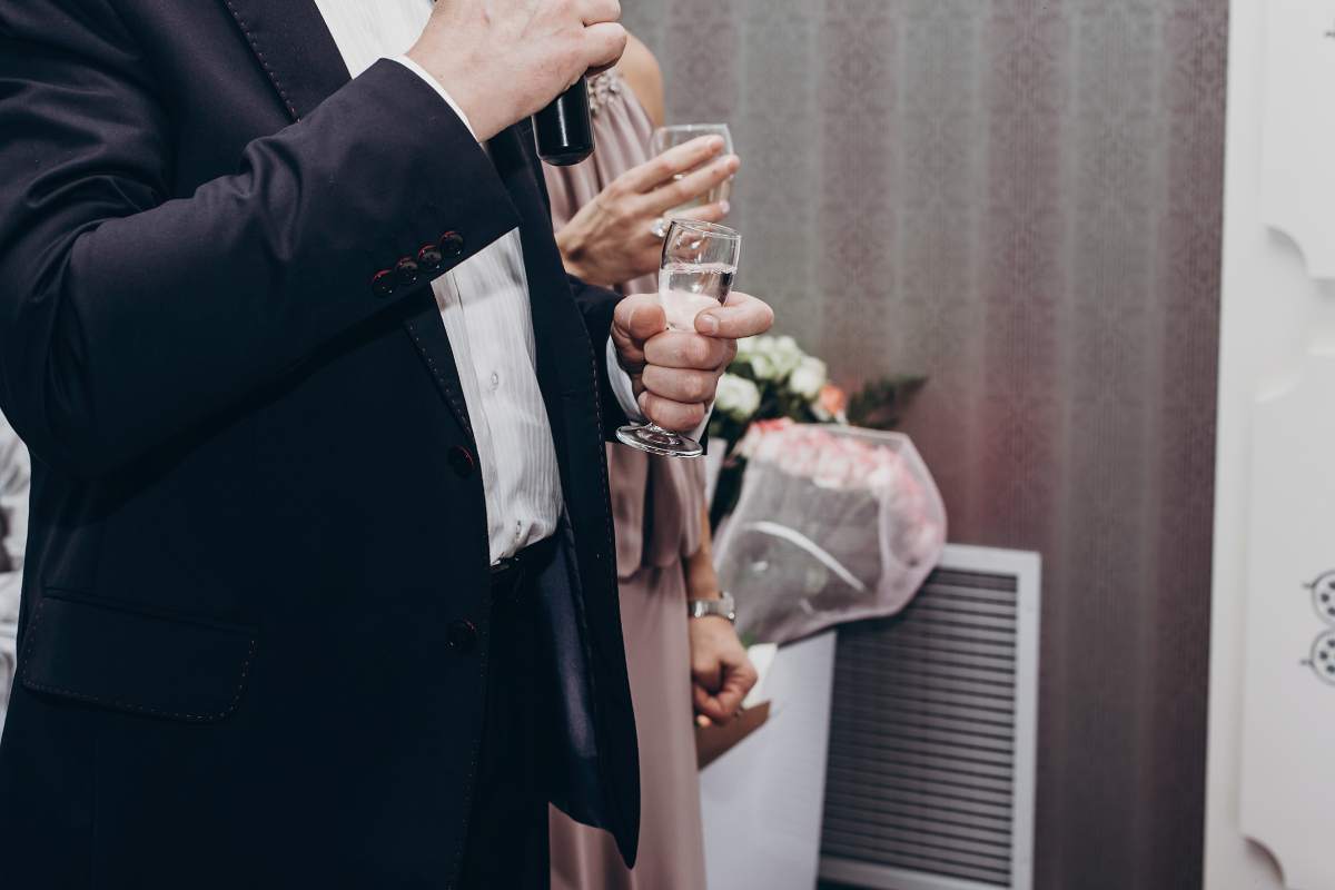 guest toasting with glasses of wine at luxury wedding reception. mother of bride and ceremony master performing a toast with drinks. expensive wedding catering. space for text