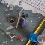 Plaster repair work laying tile, trowel in a man worker using measuring and marking