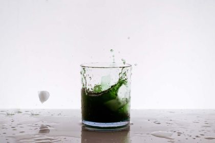 A green iced cocktail splash on the table on a white background
