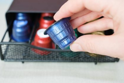 Female hand hold a capsule for a coffee machine close up.